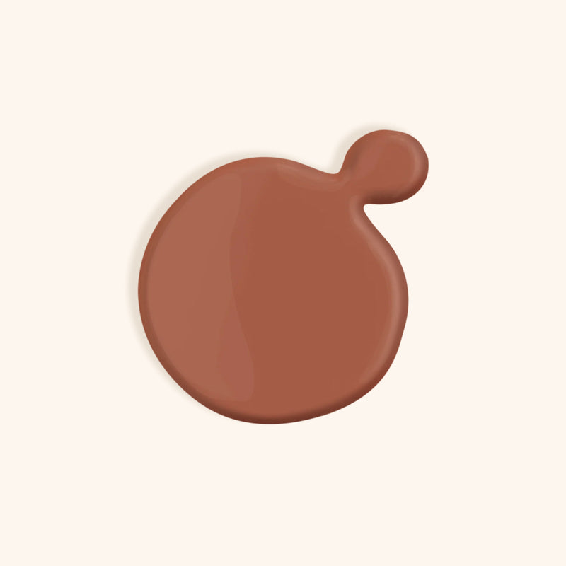 Warm nude nail polish in front of a beige background
