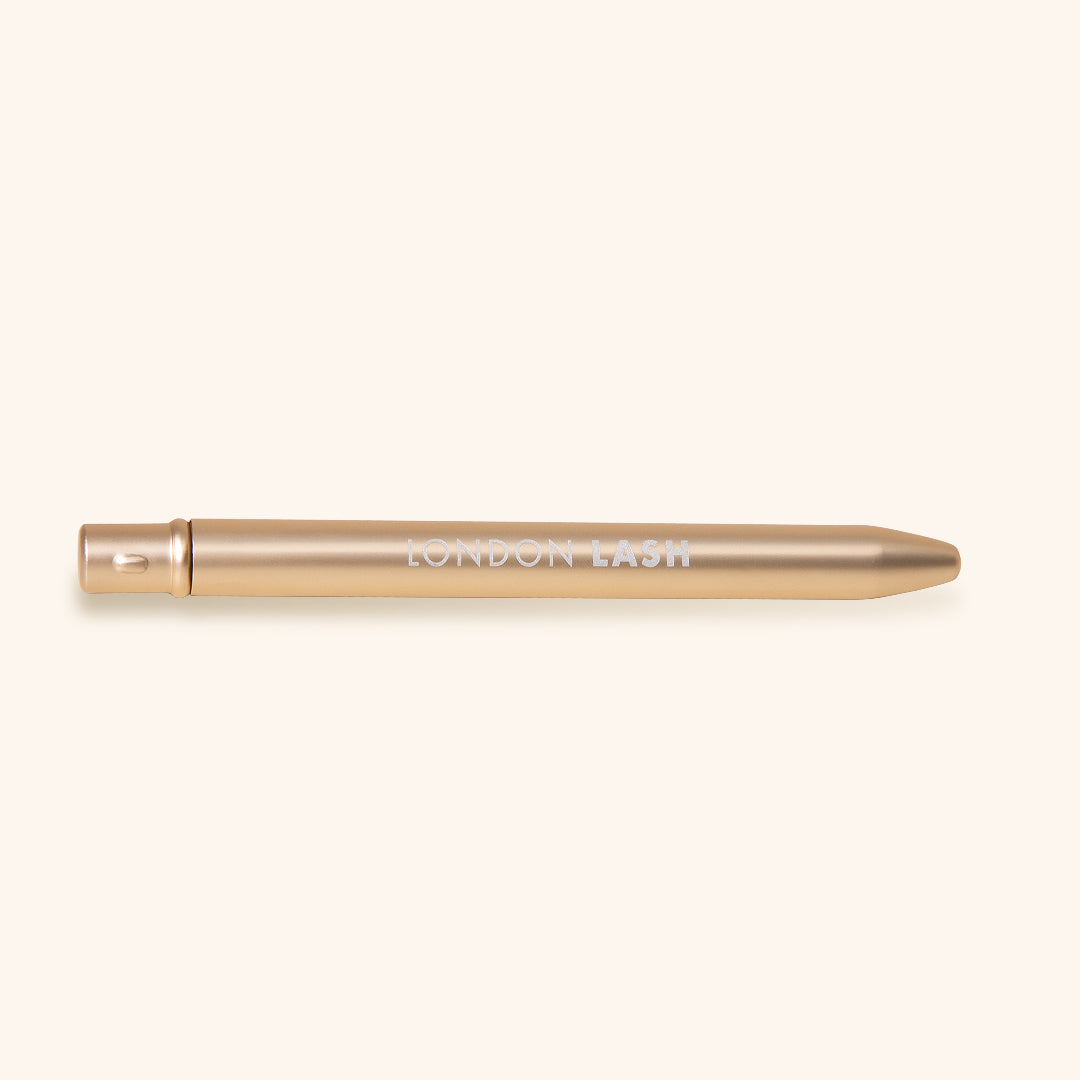 On the Go Lash Wand in gold, a reusable eyelash spoolie for perfect lash grooming.