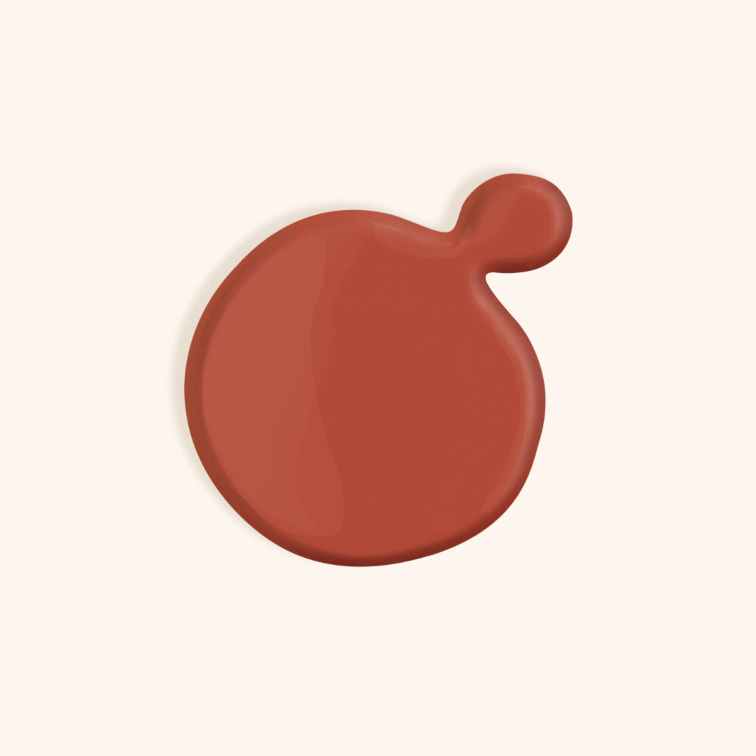 Bright coral orange nail polish in front of a beige background