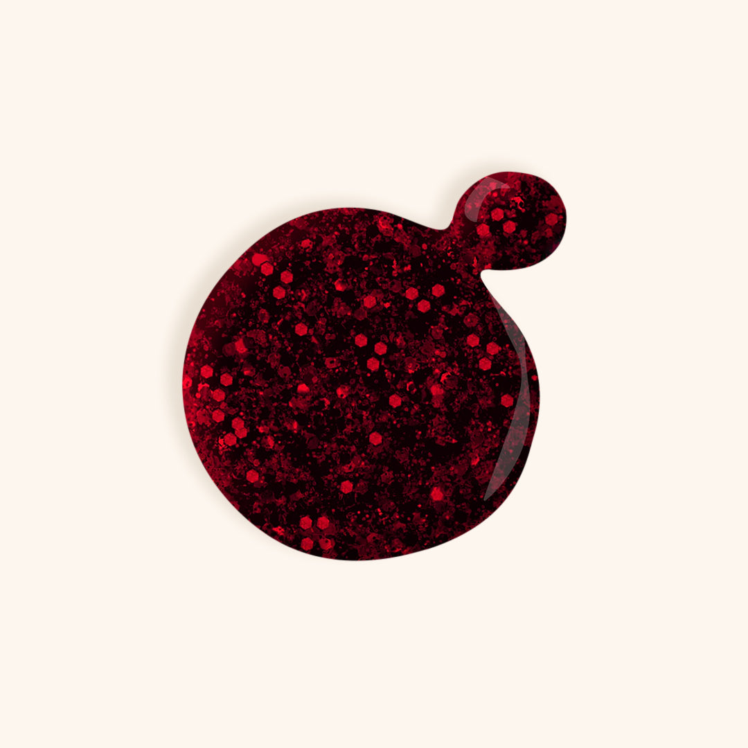 Dark red shimmer gel nail polish in front of a beige background