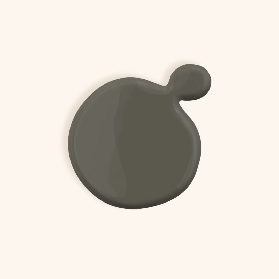 Slate grey nail polish in front of a beige background